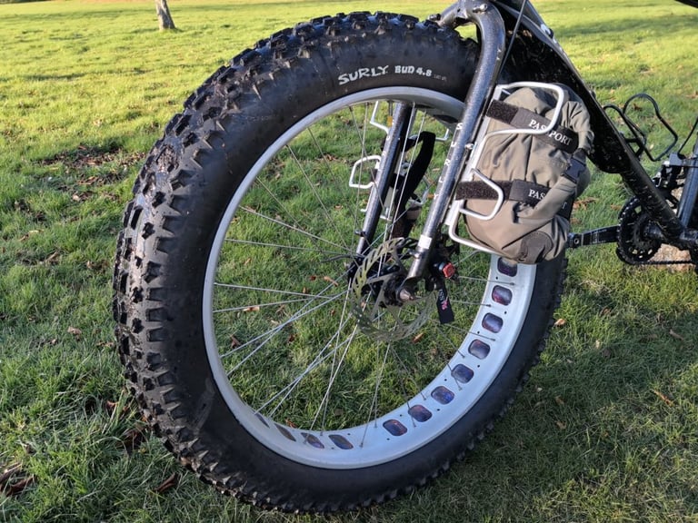 Passport Cycles Lug-Kage on a fat bike fork, carrying a green bag beside a Surly Bud 4.8 tyre.
