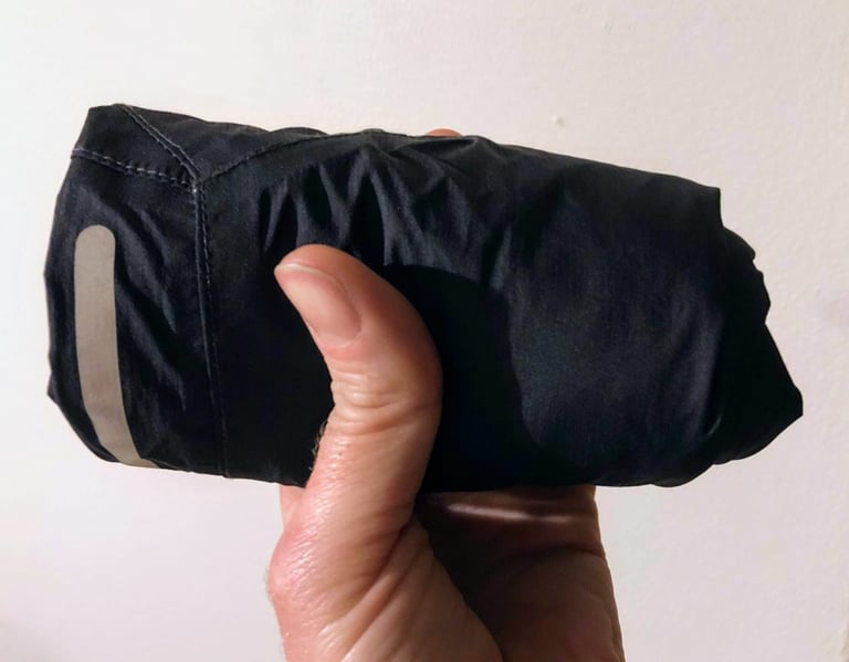 Endura MTR Waterproof Shorts rolled up small and held in one hand to show the pack size.
