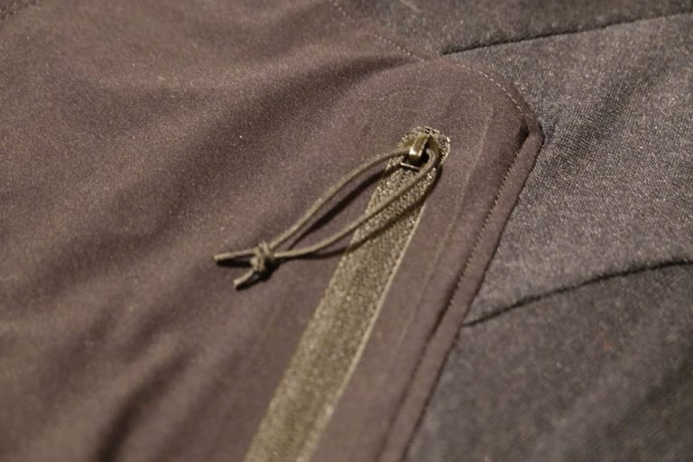 Elastic cord zip pull on a pocket of the 7Mesh Mission Jersey.