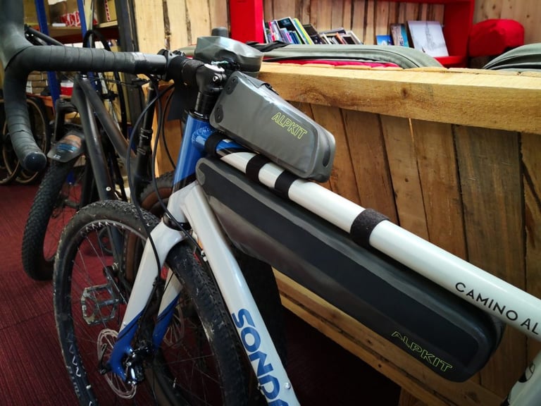 Sonder Camino AL fitted with Alpkit waterproof top tube and frame bags, parked in the Alpkit staff café.