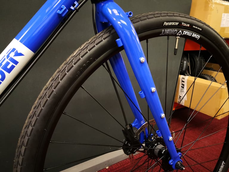 Sonder Santiago steel fork with multiple bolt-on mounts for racks and mudguards, and a Panaracer Tour tyre.