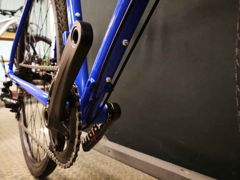Underside of the Sonder Santiago downtube with cable guides and bosses, above the SRAM crank.