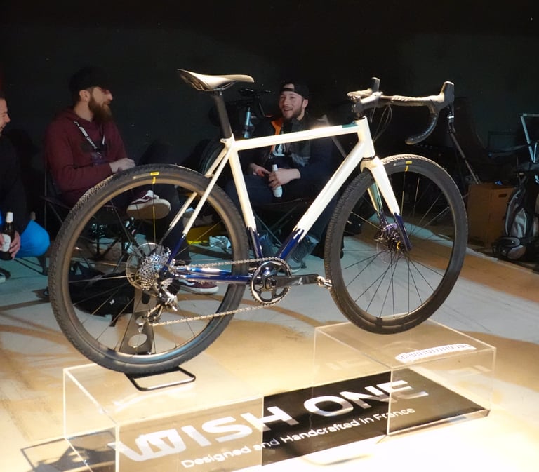 Wish One Gravel prototype in white and blue on an acrylic display plinth at the Kolektif Berlin Bike Fair.