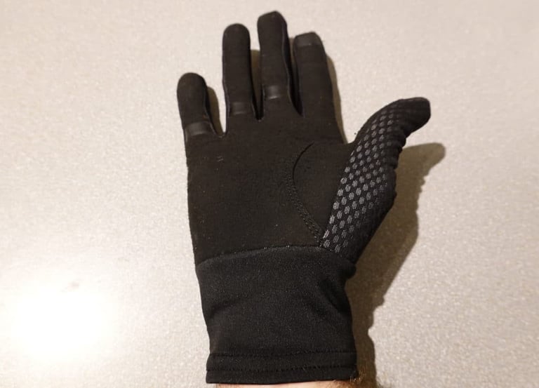 Palm of the black Gore Infinium glove, thin with no padding, silicone dots on the thumb and long elasticated cuff.