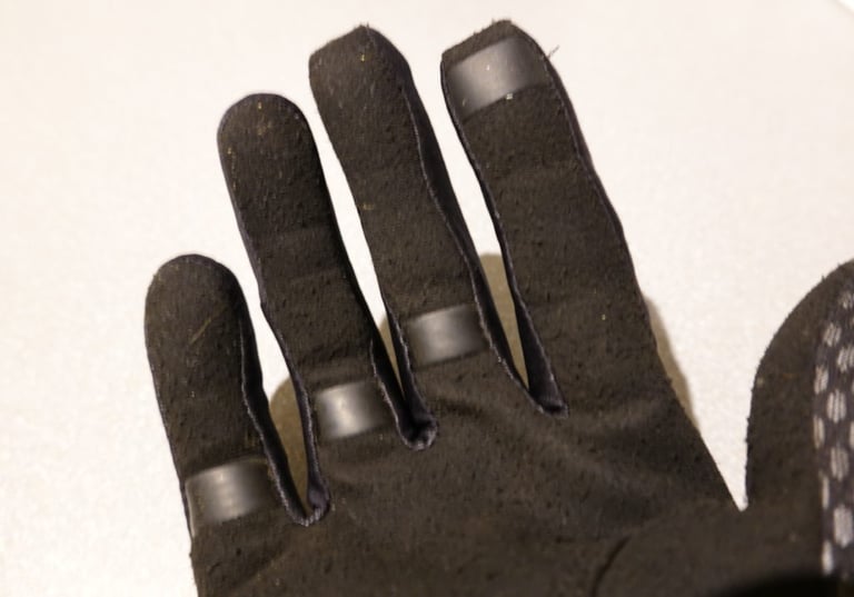 Close-up of the Gore Infinium glove's fingertips with silicone grip prints on the palm side.
