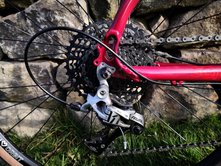 SRAM Rival 1 clutch rear derailleur and wide-range cassette on the Sonder Camino AL, with a Sonder Orbit rim behind.