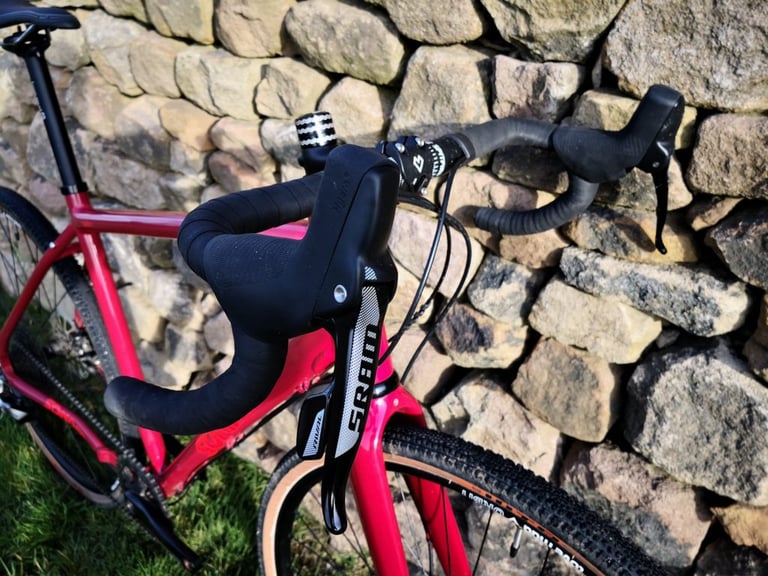 Close-up of the Sonder Camino AL's drop bars with a SRAM hydraulic Rival 1 brake lever and black bar tape.