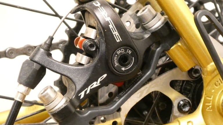 TRP Spyre mechanical disc brake caliper on the gold rear stay of the All City Cosmic Stallion.