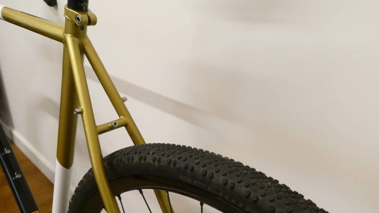 Gold seatstays and seat tube of the All City Cosmic Stallion, with rack mounts above the rear tyre.