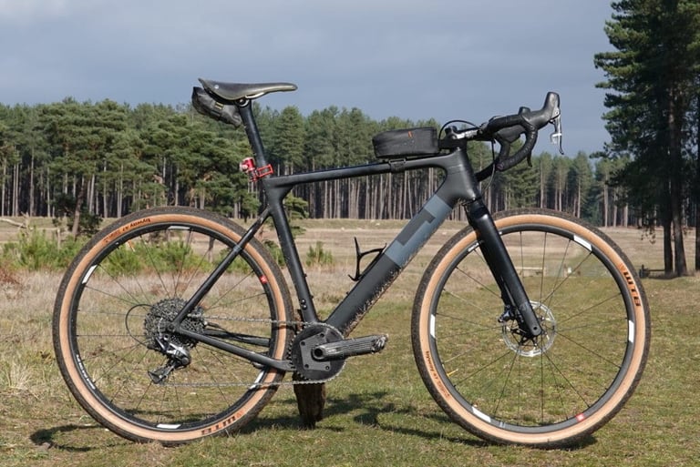 Side view of the 3T Exploro LTD test bike, black with a grey downtube panel, on 650b tan-wall WTB Byway tyres.