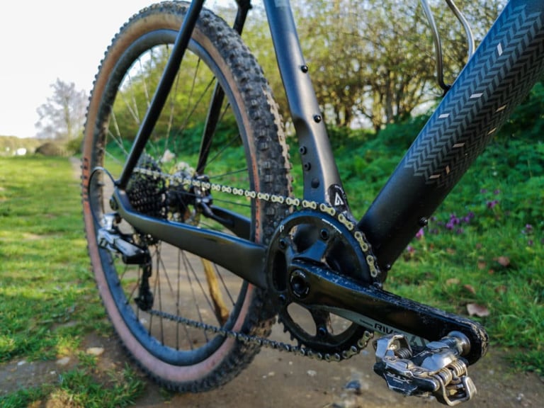 Close-up of the SRAM Rival 1x crank, chainring and rear mech on the Bombtrack Hook EXT-C, with a tan-wall rear tyre.
