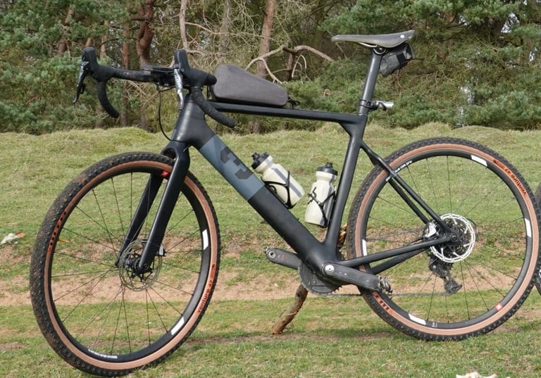 3T Exploro gravel bike on WTB Venture 47 tyres, parked on grass with a top-tube bag and two bottles.