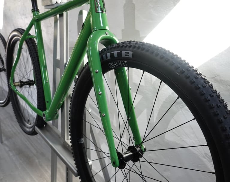 Front end of a green Mason Bokeh 2, its Parallax2 fork showing mounting bosses above a Hunt wheel and WTB tyre.