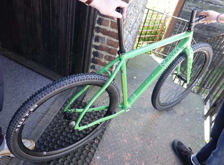 Part-built green Mason Bokeh 2 with no saddle fitted, held up on a metal landing outside the barn.