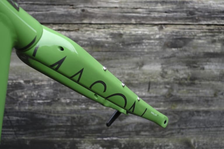 Green Mason Parallax2 carbon fork leg with its new mounts, photographed against weathered wooden boards.