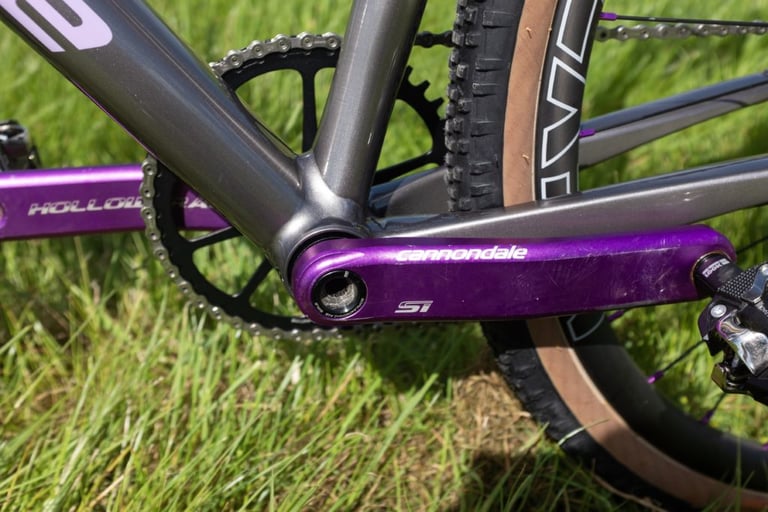 Purple anodised Cannondale Hollowgram SI crank and chainring on the Grinduro Slate, close up in the grass.