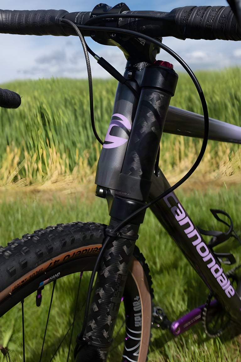 Head tube and Lefty Oliver fork of the Cannondale Slate with a lilac Cannondale logo and WTB Sendero tyre.