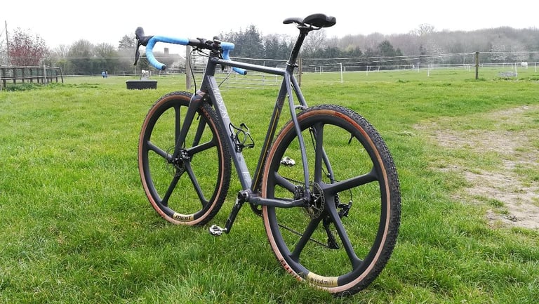 Mason Bokeh gravel bike fitted with Merit Windmill five-spoke wheels, standing in a grassy paddock.