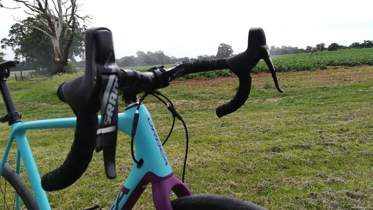 Ritchey WCS Ergomax tops and hoods with SRAM levers on an Orbea, beside a crop field.