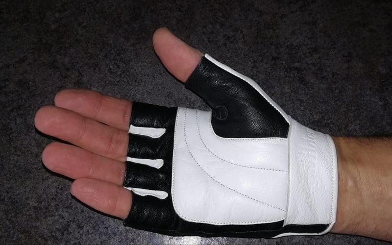 Palm of a hand wearing a Galibier Ginettaccio mitt, with white padded leather and a black thumb.