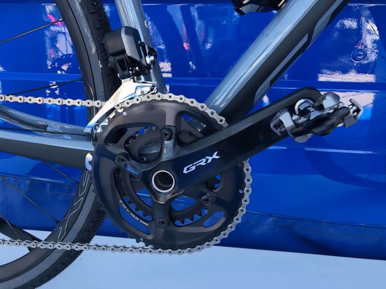 Shimano GRX FC-RX810 double crankset with front derailleur and clipless pedal on a gravel bike.