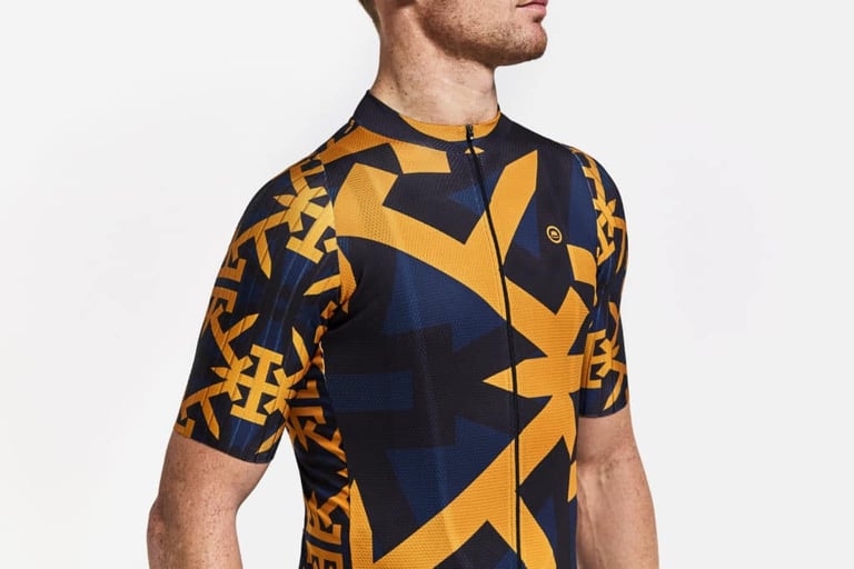 Chapeau Club Jersey Pro short sleeve with raw-cut, ungripped sleeve, in a navy and orange geometric pattern.