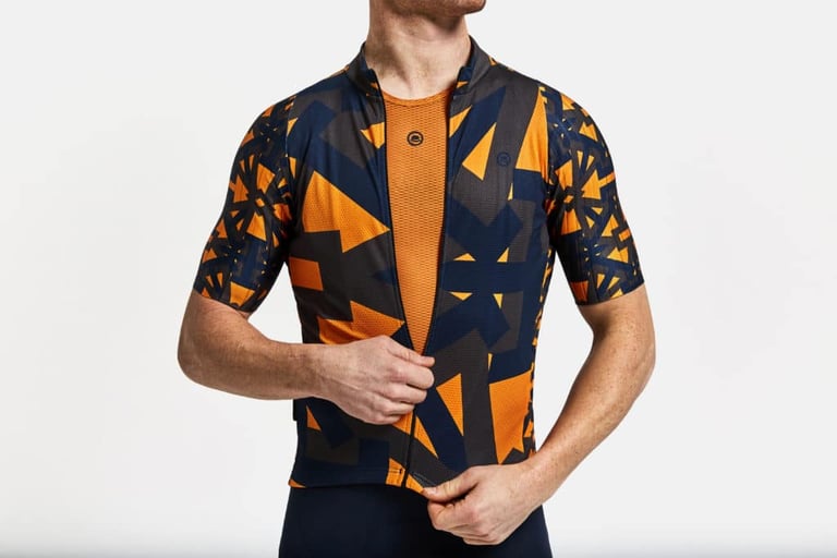 Chapeau Club Jersey Pro in aubergine and orange over an orange mesh base layer, zipped halfway up.