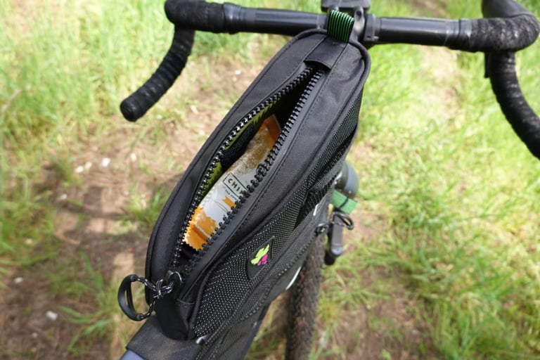 Top-down view into the open Miss Grape Node 2H bag, showing the lining and a snack bar inside.