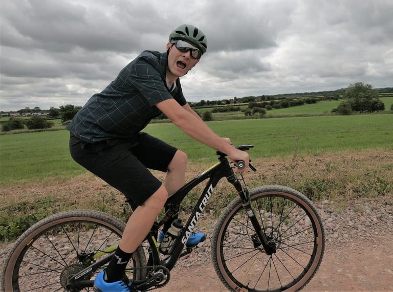 Rider on a Santa Cruz mountain bike on a gravel track wearing Morvelo Selector shorts.