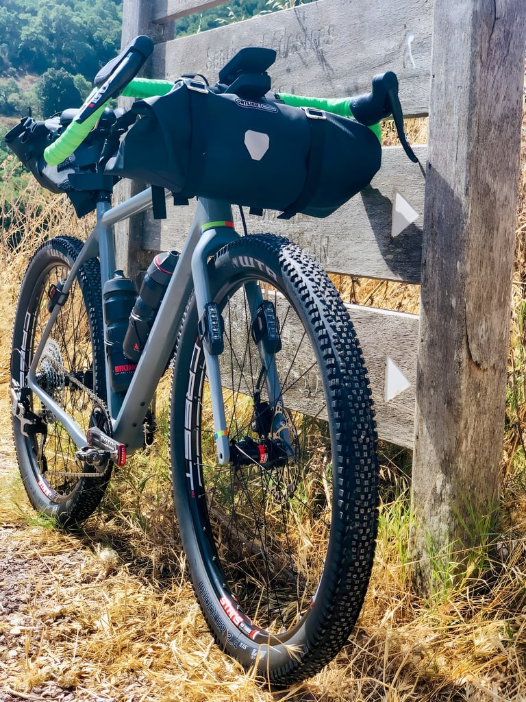 Front view of Axel Carion's OPEN WI.DE with Ortlieb handlebar bag, green bar tape and a WTB Riddler tyre.