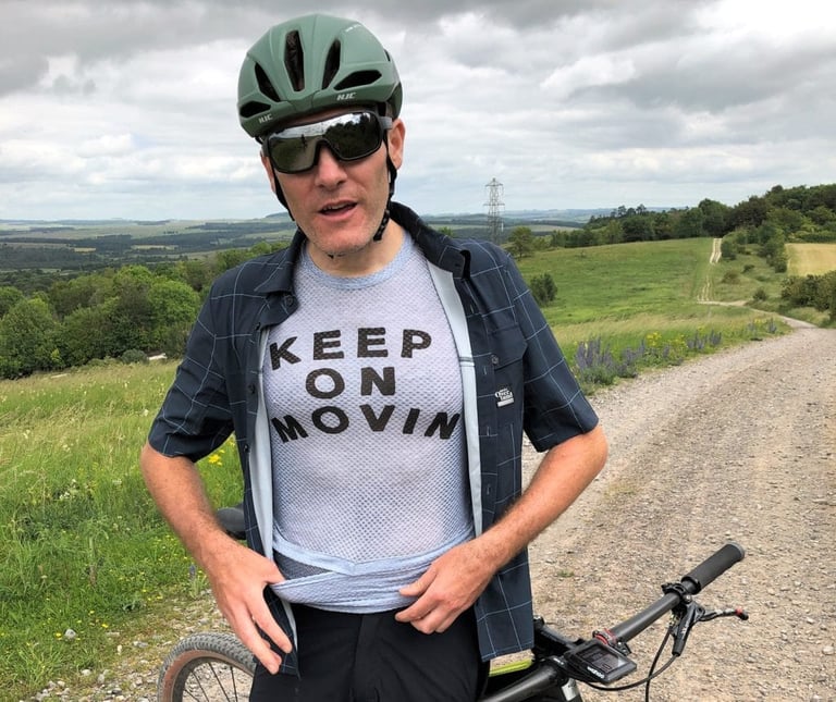 Rider opens the Overland shirt to show the Dual Baselayer-Jersey with its "Keep on movin" front print.