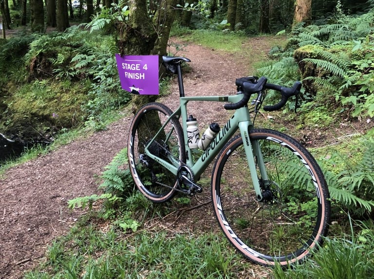 Cipollini MCM All Road leaning against a tree at the Stage 4 finish sign of Grinduro, in woodland.