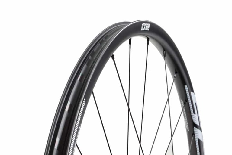 Scope O2 carbon rim with spokes and logo, seen from an angle to show the wide profile.