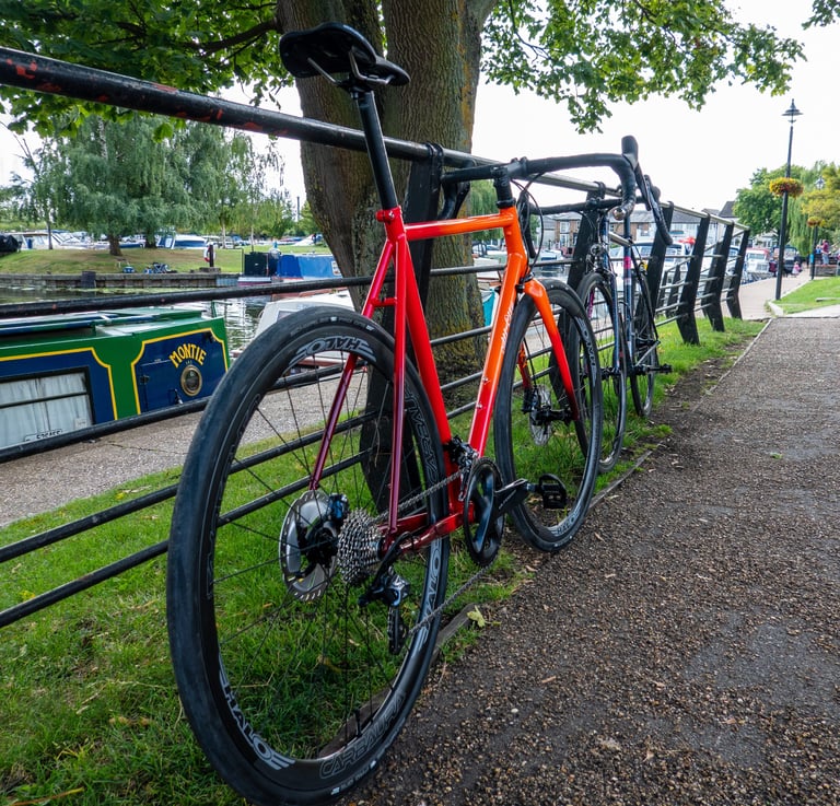 Rear view of the All City Zig Zag showing its Ultegra drivetrain and Halo wheel, with Mr Pink further down the railing.