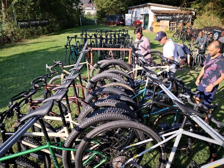 Rows of Bombtrack gravel and mountain bikes lined up on the grass for Groundwork guests to choose from.