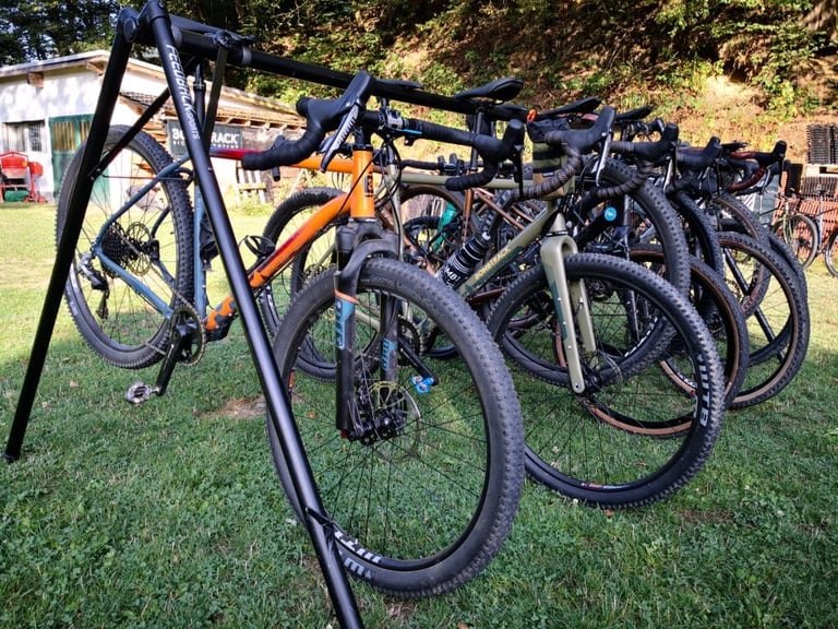 Bombtrack Hook ADV 2020 hanging in a bike rack alongside other Bombtrack models on a lawn.
