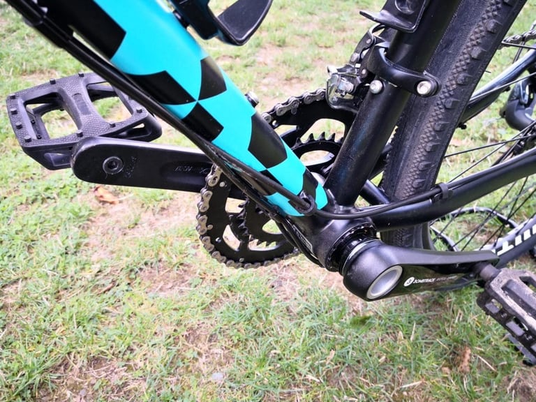Bombtrack 30mm-spindle double chainset and T47 bottom bracket on the teal down tube of the Hook WMN, with flat pedals.
