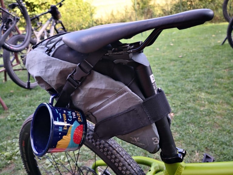 Apidura saddle pack on the Bombtrack Beyond Junior with an enamel mug hanging from its strap.