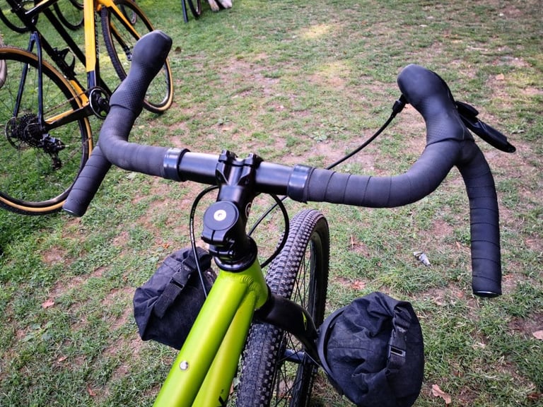 Flared 38cm drop bars and stem on the Bombtrack Beyond Junior, with small front bags either side of the fork.