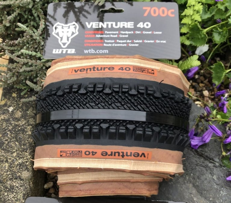 New WTB Venture 40 700c tanwall tyre in its packaging, showing the chevron centre tread and side knobs.