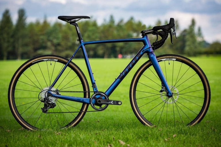 Blue Vitus Energie CRX cyclocross bike with SRAM Force 1 and Prime wheels, side view on a grass field.