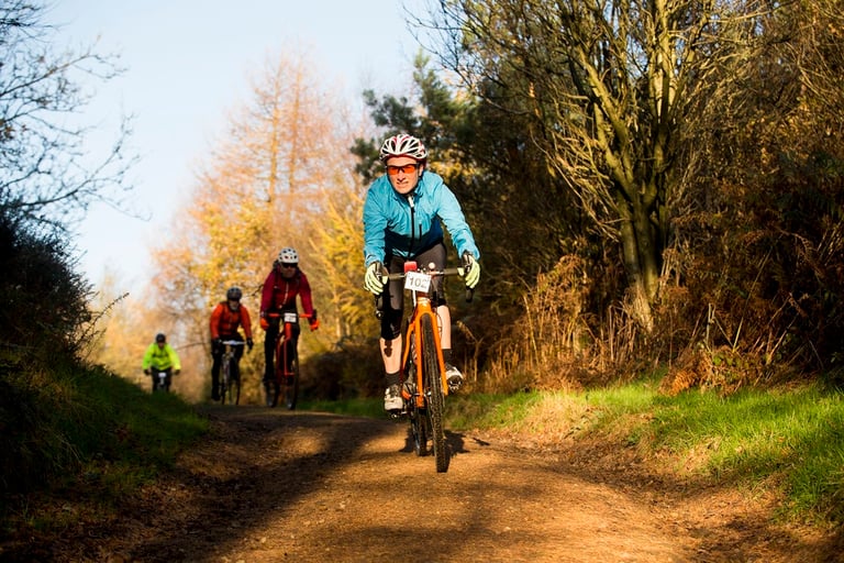 Riders on a woodland trail in autumn light at the Top of the Rock gravel sportive near Sutton Bank.