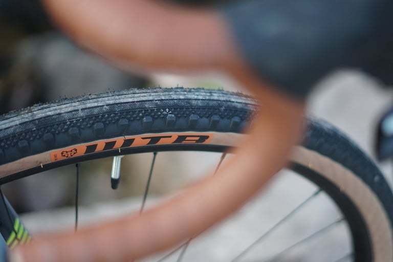 Close-up of the tan-wall WTB Byway tyre tread and rim on the Trek Crockett, brown handlebar blurred in the foreground.