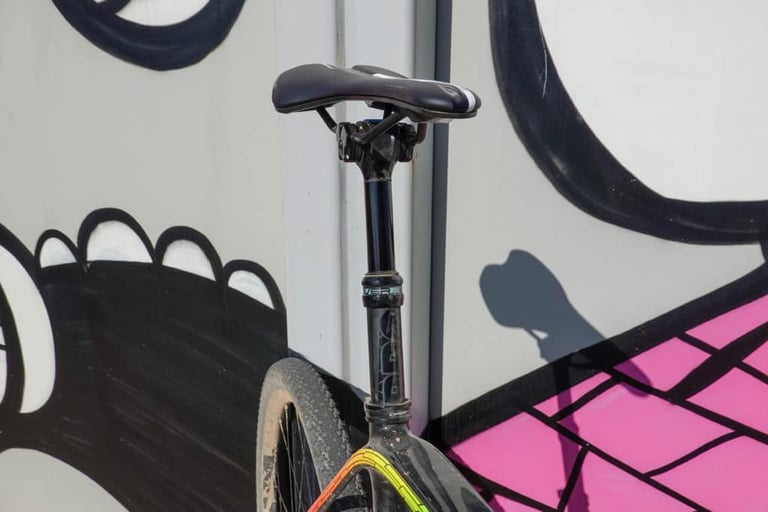 PRO Discover Dropper Post fully extended on a gravel bike leaning against a painted mural wall.