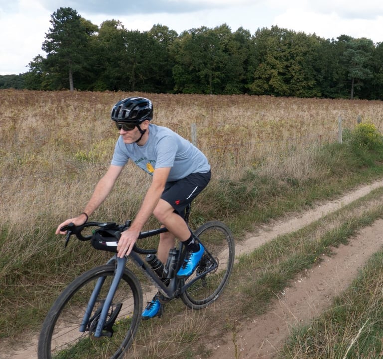 Riding the Aussie Grit Ignite shorts with a grey T-shirt and a bar bag along a field-edge track.