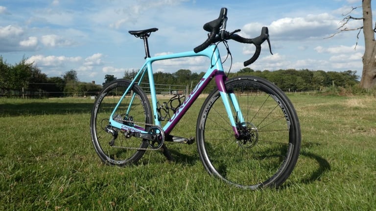 Orbea Terra gravel bike fitted with Halo Carbaura RCD 35mm carbon wheels, standing on grass in a field.
