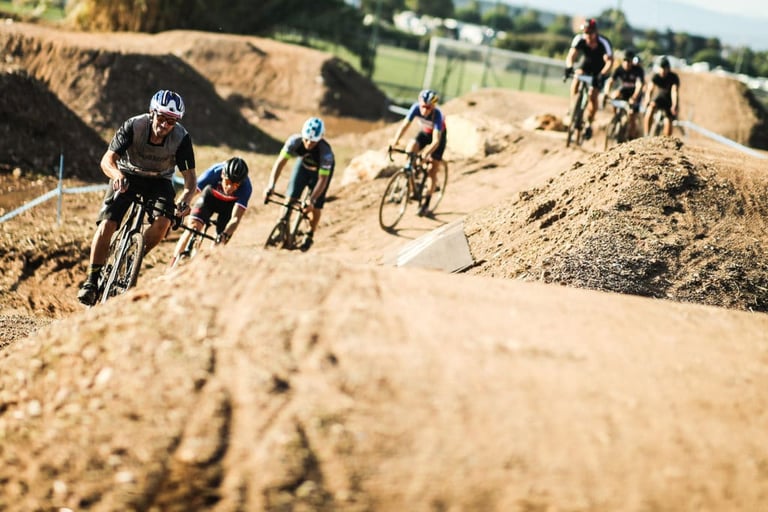 Gravel Origins 83 riders in a bunch tackle dirt humps on a built off-road course at Roc d'Azur.