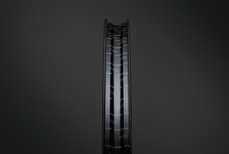 Rim profile of the Roval Terra CLX front wheel in satin carbon with gloss black logos, on a dark background.