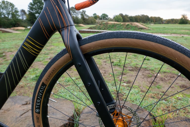 Salsa Warroad fork with a Teravail Rampart 650b tyre and orange hub, side close-up.