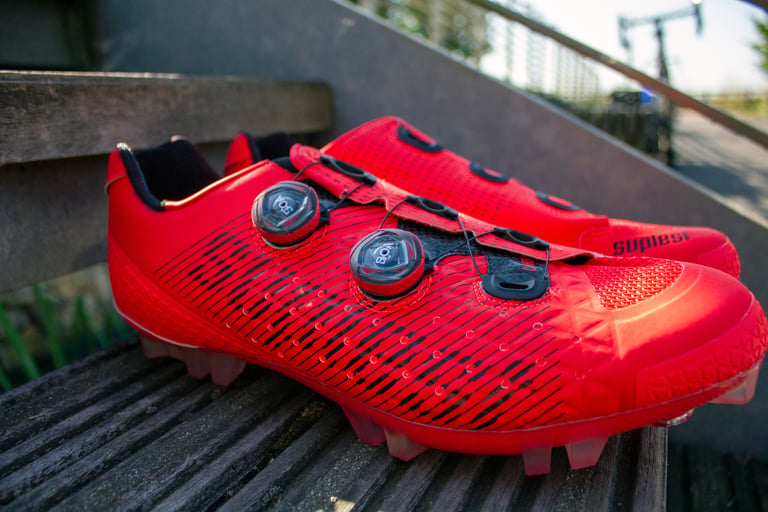 Suplest Cross Country Pro shoes in neon red, seen from the side with two BOA dials.